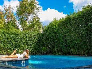 a woman laying on the edge of a swimming pool at Oak Manor Boutique Guest House in Cape Town +6 photos