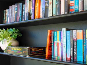 a row of books on a book shelf at Oak Manor Boutique Guest House in Cape Town