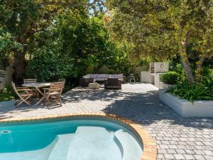 a swimming pool in a yard with a table and chairs at Oak Manor Boutique Guest House in Cape Town