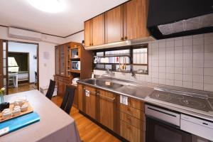 a kitchen with wooden cabinets and a counter top at 一隅居 in Yaochō