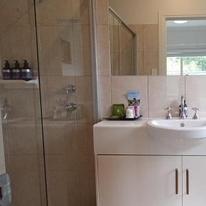 a bathroom with a sink and a shower at Hahndorf Oak Tree Cottages in Hahndorf +9 photos