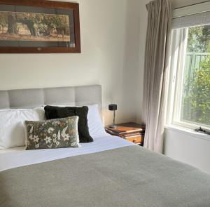 a bedroom with a large bed and a window at Hahndorf Oak Tree Cottages in Hahndorf