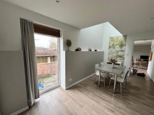 a dining room with a table and a window at Le Cosy Duplex in Amay