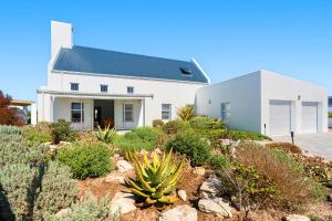 a white house on top of a hill with plants at Sugarbird in Velddrif