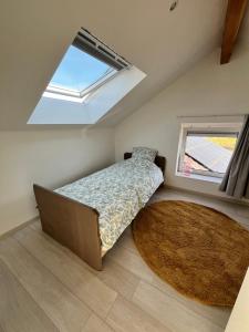 a bedroom with a bed and a rug and a window at Le Cosy Duplex in Amay