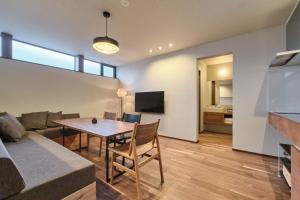 a living room with a table and a couch at Hotel GGG Asahikawa in Asahikawa