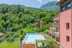 a resort with a swimming pool and mountains in the background at Magical Menaggio Vista in Menaggio