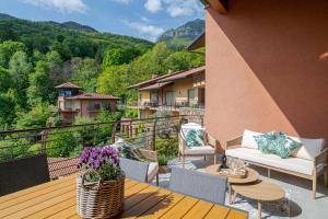a patio with a table and chairs on a balcony at Magical Menaggio Vista in Menaggio