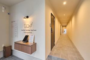 a hallway of a hospital with a sign on the wall at Hotel GGG Asahikawa in Asahikawa