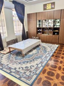 a bedroom with a bed and a large rug at Darvozai Samarkand guest house in Samarkand