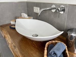 a white sink on a wooden counter in a bathroom at Simply Enjoy Ferienwohnungen in Losheim +16 photos