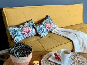 a couch with pillows and a cup of coffee on a table at Simply Enjoy Ferienwohnungen in Losheim