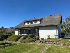 a large white house with a gray roof at Simply Enjoy Ferienwohnungen in Losheim