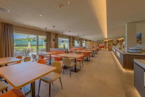 ein Restaurant mit Tischen und Stühlen und einer Cafeteria in der Unterkunft Hotel Cornelian Suites & Rooms in Appiano sulla Strada del Vino
