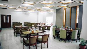 a dining room with wooden tables and chairs at White Leaf Resort - Green River View Resort in Dolālghāt
