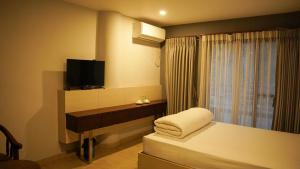 a hotel room with a bed and a television at White Leaf Resort - Green River View Resort in Dolālghāt