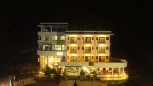 a large building with lights on it at night at White Leaf Resort - Green River View Resort in Dolālghāt