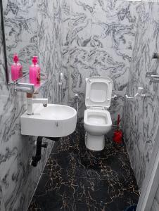 a bathroom with a white toilet and a sink at New Happy bay in Arugam Bay