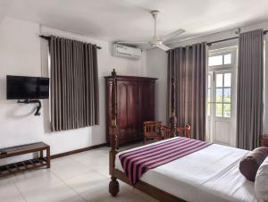 a bedroom with a bed and a flat screen tv at Sky Lodge in Kandy