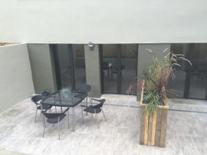 a patio with a glass table and chairs on a building at L'hetre in Saint-Sébastien-sur-Loire