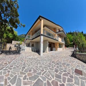 a large house with a stone driveway at Villa Arianna Lake View Apartments with Pool in Tignale