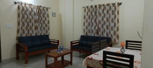 a living room with two chairs and a table at Chippy Residency Coorg in Gonikoppal