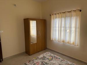 a bedroom with a wooden door and a window at Chippy Residency Coorg in Gonikoppal