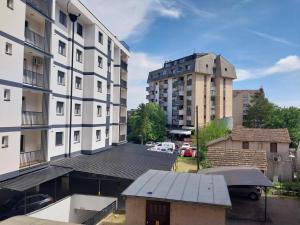 Blick auf einen Parkplatz zwischen zwei Gebäuden in der Unterkunft Apartmani Sofronic Loznica 2 in Loznica