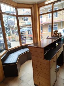 a desk with a bench in front of a window at Hotel Premier in Manāli