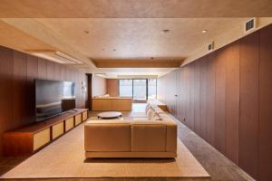 a living room with a couch and a flat screen tv at 開土 KAIDO Hotel in Sapporo