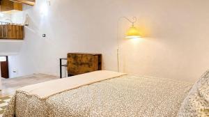 a bedroom with a bed with a light on the wall at La cassetta 22 in Castelnuovo dellʼAbate