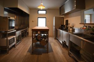 a large kitchen with stainless steel appliances and a counter at Sheltered Inn Hakuba in Hakuba