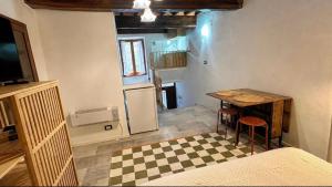 a small kitchen with a table and a refrigerator at La cassetta 22 in Castelnuovo dellʼAbate