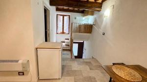 a small kitchen with a counter and a stairway at La cassetta 22 in Castelnuovo dellʼAbate +2 photos