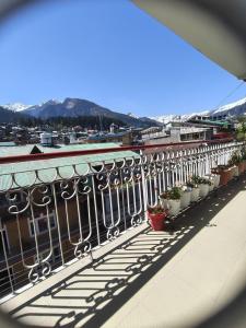 a balcony with potted plants on a building at Hotel Premier in Manāli