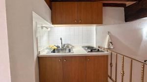 a kitchen with a sink and wooden cabinets at La cassetta 22 in Castelnuovo dellʼAbate