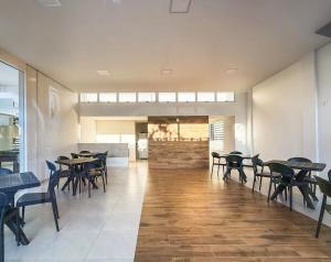 a dining room with tables and chairs and a fireplace at Casa condominio Carpe Diem in Marechal Deodoro