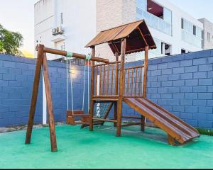 a wooden playground with a slide on the water at Casa condominio Carpe Diem in Marechal Deodoro