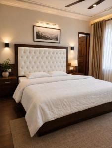 a bedroom with a large bed with a white bedspread at Hotel Premier in Manāli
