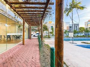 a brick walkway with a pergola next to a pool at Casa condominio Carpe Diem in Marechal Deodoro