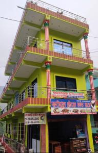 a yellow building with a balcony and signs on it at Kharidhunga hotel and lodge in Rāmechhāp