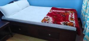 a bed with a red blanket on top of it at Kharidhunga hotel and lodge in Rāmechhāp