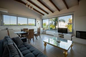 a living room with a couch and a table at Le petit luxury apartment in Preveza