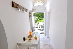 a white table in a hallway with an open door at Masseria Pagliamonte in San Vito dei Normanni