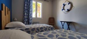 a bedroom with two beds and a window at Maison du Palmier in La Brée-les-Bains