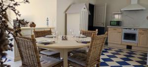 a dining room with a table and chairs in a kitchen at Maison du Palmier in La Brée-les-Bains +6 photos