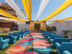 a long aisle with blue chairs and a colorful carpet at Hotel Rajwada palace in Orchha