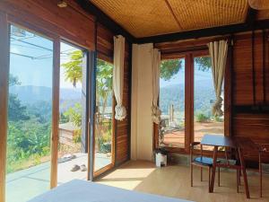 a bedroom with a bed and a table with a view at Motho Homestay โมโทโฮมสเตย์ in Chom Thong