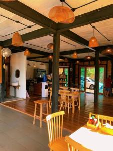 a dining room with tables and chairs in a building at Motho Homestay โมโทโฮมสเตย์ in Chom Thong