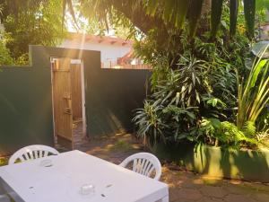 a white table and chairs in a garden at Michelangelo - Zur See in Ballito